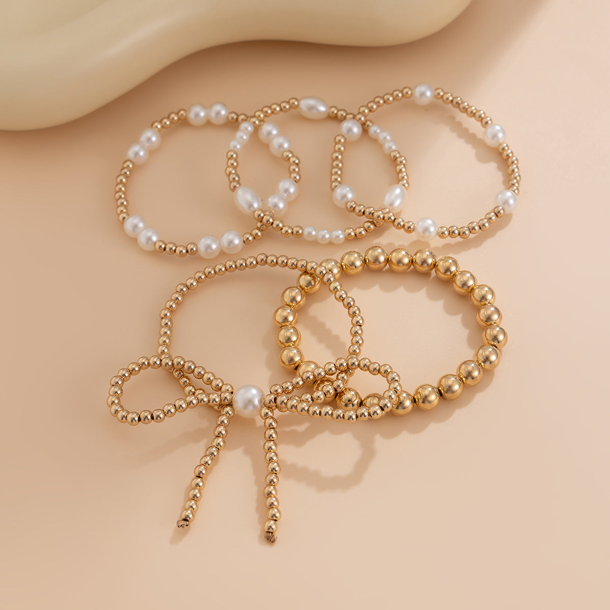 Set de Pulseras Doradas con Perlas – 5 Piezas con Lazo Elegante